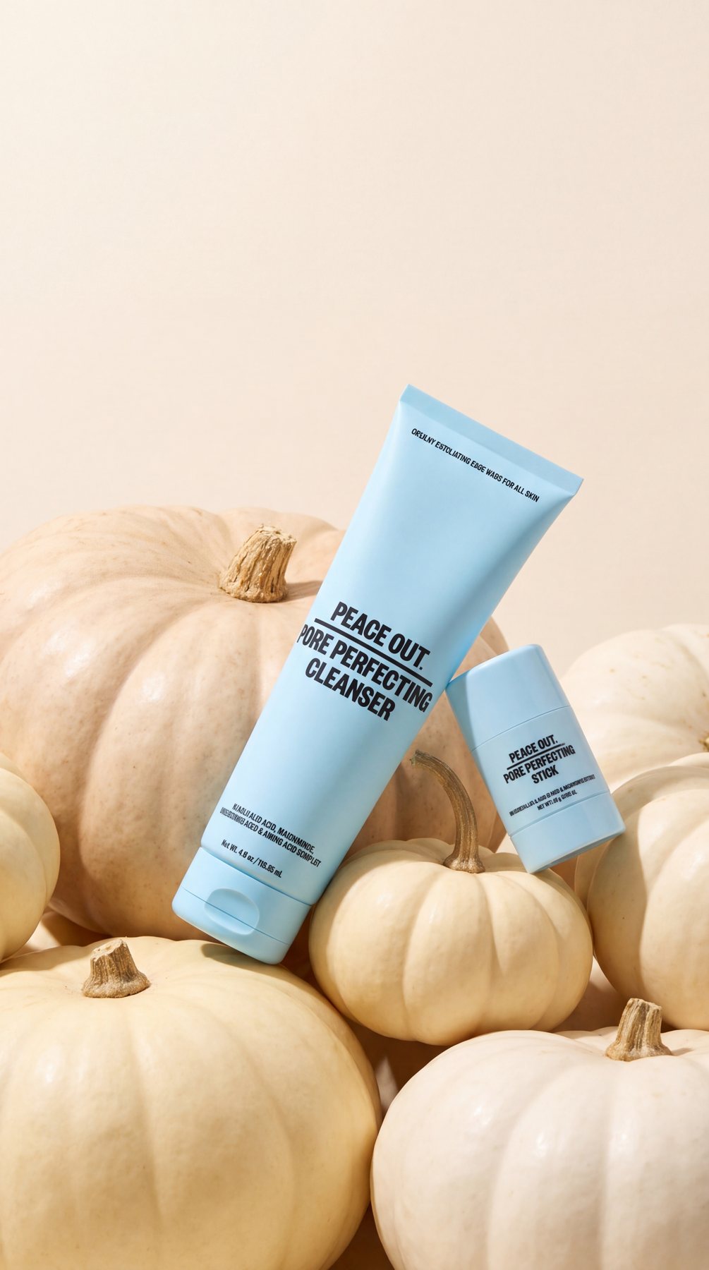 Pore Perfecting Cleanser and Pore Perfecting Stick resting on a pile of white pumpkins